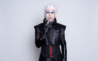 Hellraiser-inspired costume with pins and black leather outfit for Halloween.