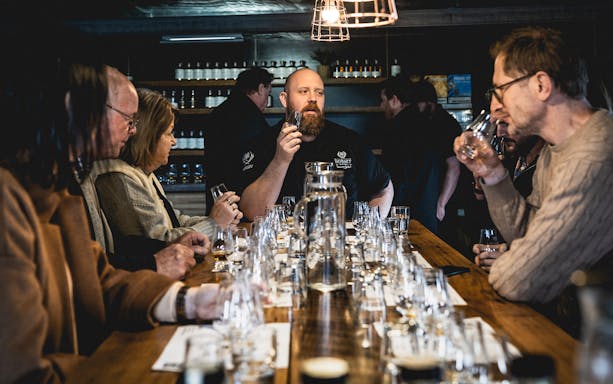Group tasting whiskey at a distillery in Tasmania, part of Hobart tour.