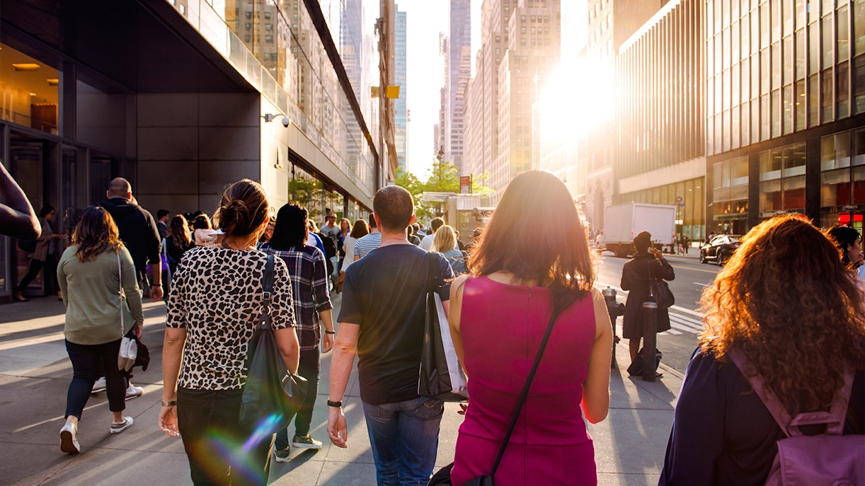 People walking on a sunny street in New York City during Empire State Building tour.