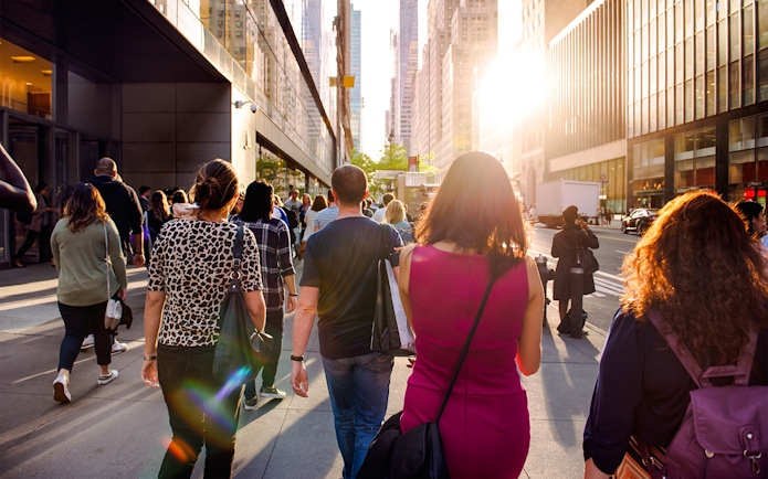 People walking on a sunny street in New York City during Empire State Building tour.