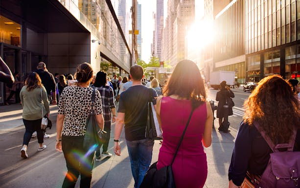 People walking on a sunny street in New York City during Empire State Building tour.