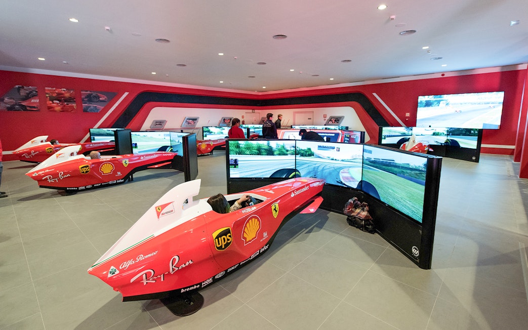 F1 simulators at Ferrari Land with people experiencing virtual racing.