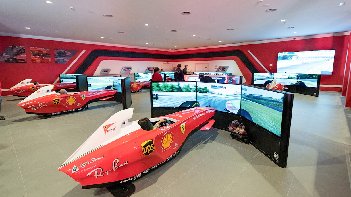 F1 simulators at Ferrari Land with people experiencing virtual racing.