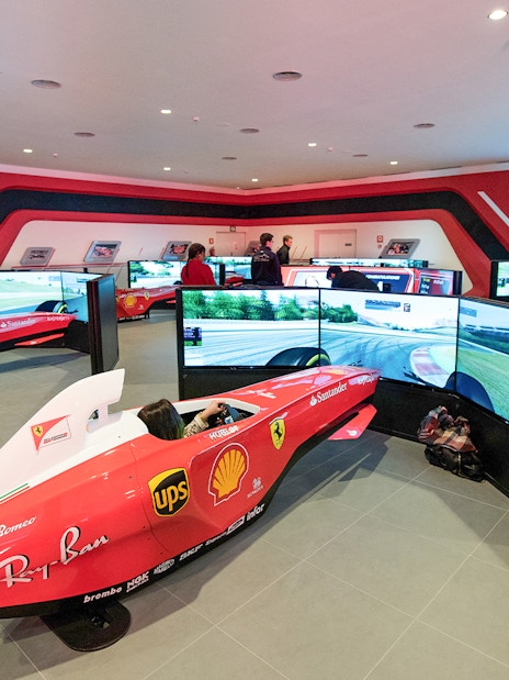 F1 simulators at Ferrari Land with people experiencing virtual racing.