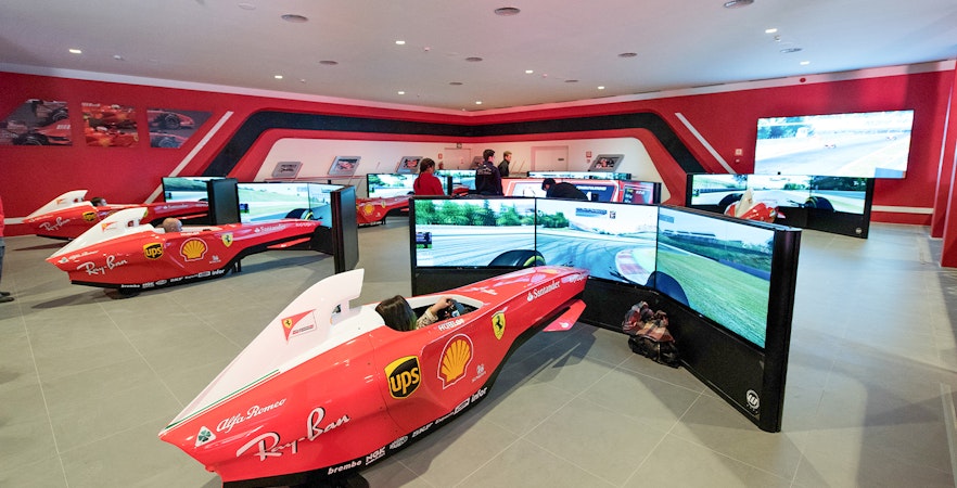 F1 simulators at Ferrari Land with people experiencing virtual racing.