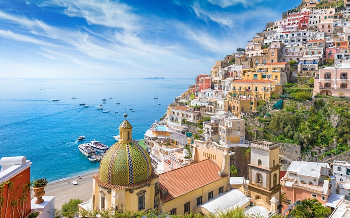 Panoramic view of Positano's colorful cliffside buildings and dome, Amalfi Coast.