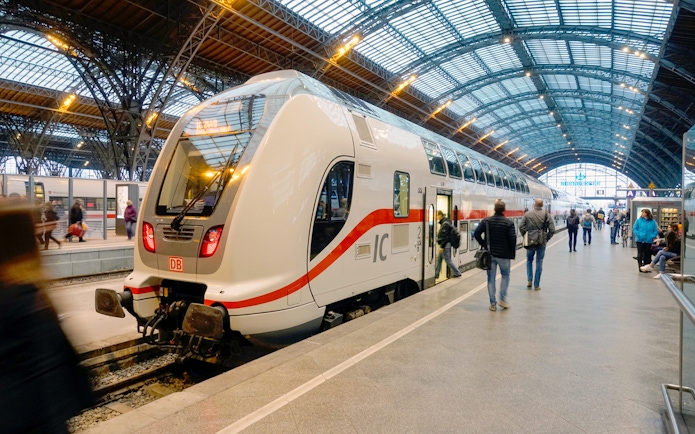Intercity train at a German station platform with passengers boarding.