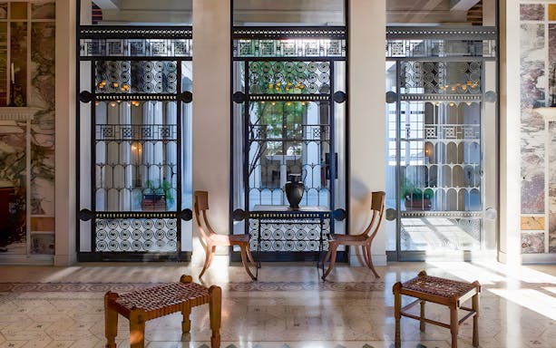 Elegant interior of Villa Kerylos with decorative ironwork and wooden furniture.
