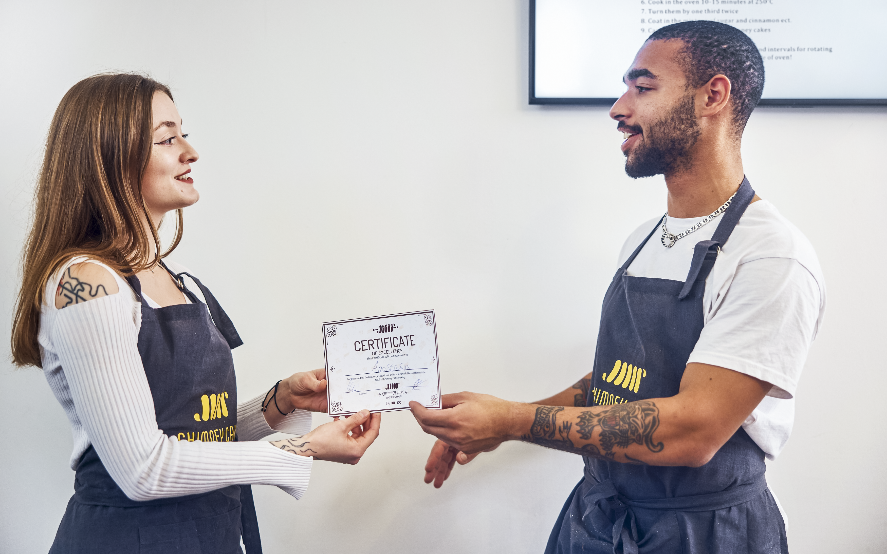 Participants receiving certificates at Traditional Chimney Cake Workshop, Budapest.