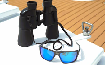Binoculars and sunglasses on a boat deck for Benalmádena dolphin-watching cruise.