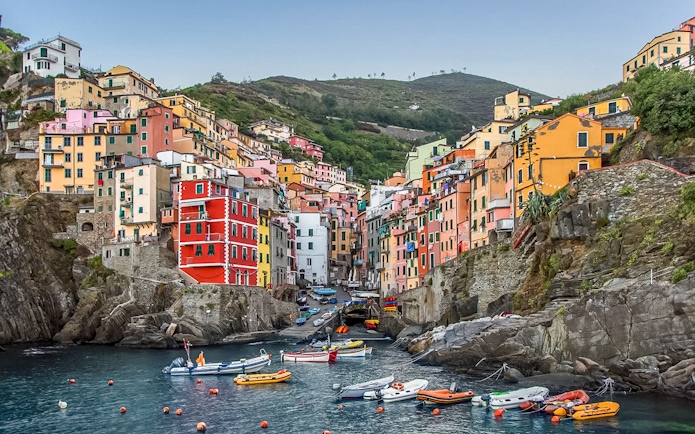 Colorful buildings and boats in Riomaggiore, Cinque Terre, viewed from the water.