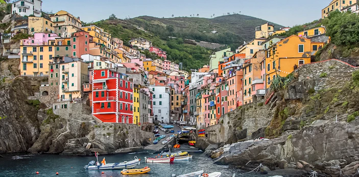 Colorful buildings and boats in Riomaggiore, Cinque Terre, viewed from the water.
