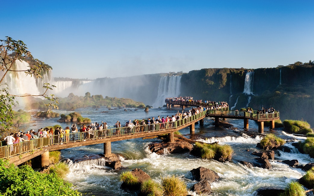 Visitors on a walkway overlooking Iguazu Falls, Brazil.