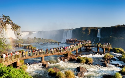 Visitors on a walkway overlooking Iguazu Falls, Brazil.