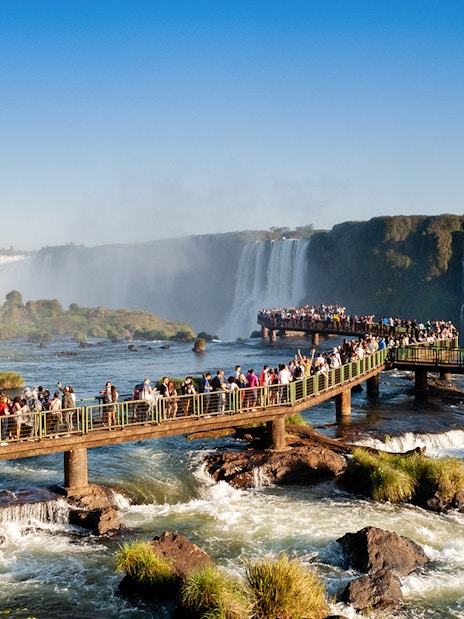 Visitors on a walkway overlooking Iguazu Falls, Brazil.
