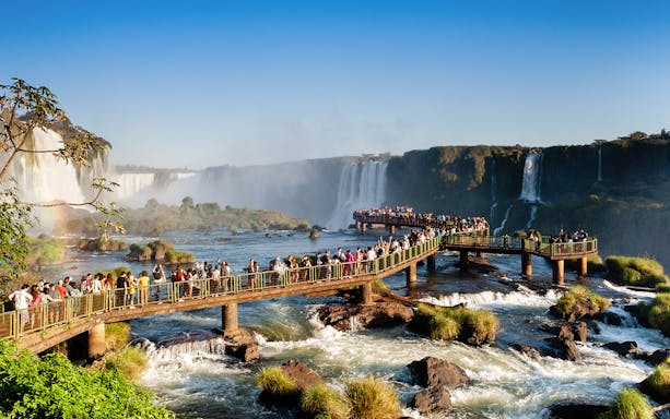 Visitors on a walkway overlooking Iguazu Falls, Brazil.