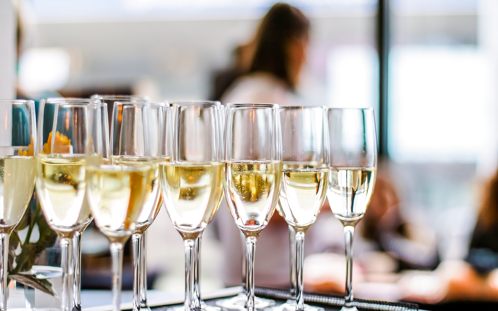 Champagne glasses lined up at a social event.