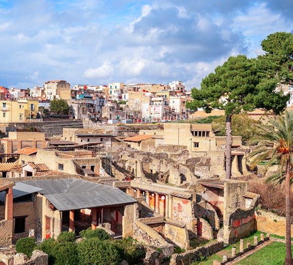 Ancient ruins of Herculaneum with modern town in background, Sorrento to Herculaneum tour.