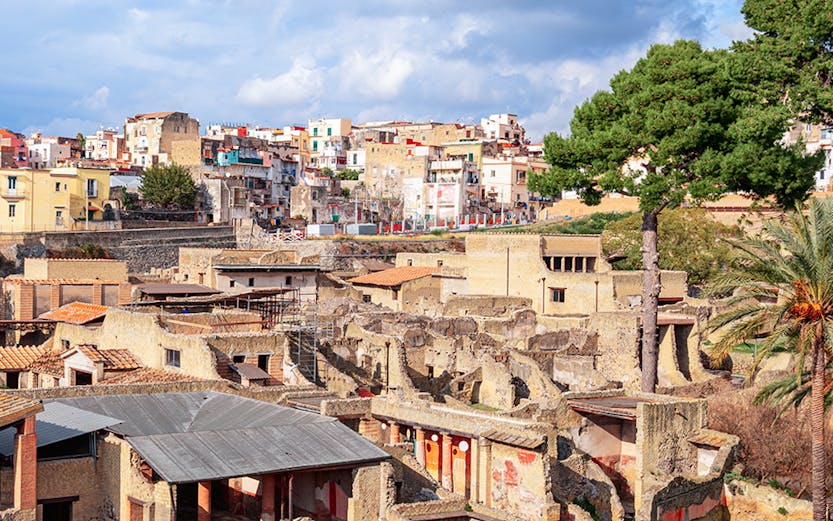 Ancient ruins of Herculaneum with modern town in background, Sorrento to Herculaneum tour.