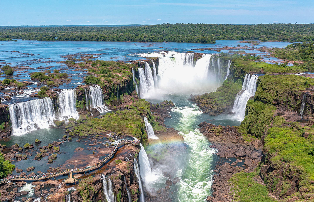 Aerial view of Iguazu Falls cascading through lush rainforest, Argentina-Brazil border.