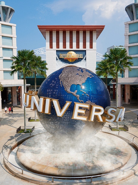Universal Studios Singapore entrance with iconic globe and palm trees.