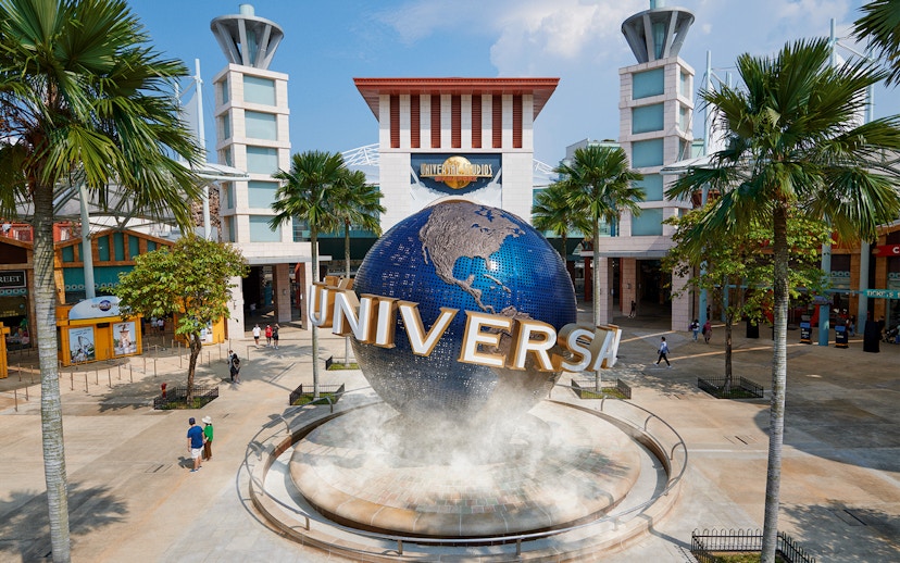 Universal Studios Singapore entrance with iconic globe and palm trees.