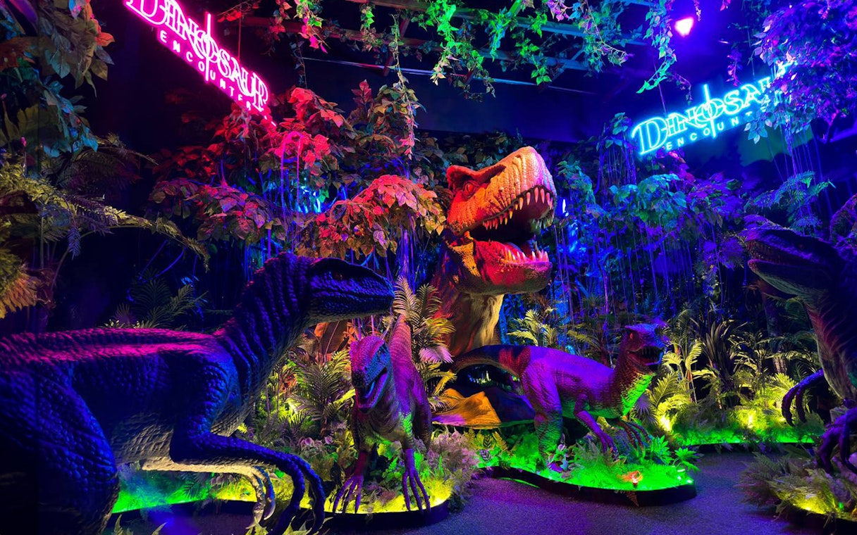 Dinosaurs exhibit with vibrant lighting at Wetland Studios Putrajaya, Malaysia.