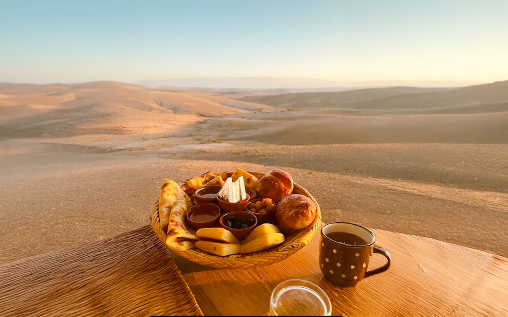 Breakfast spread with pastries and tea in Agafay desert, Marrakech.