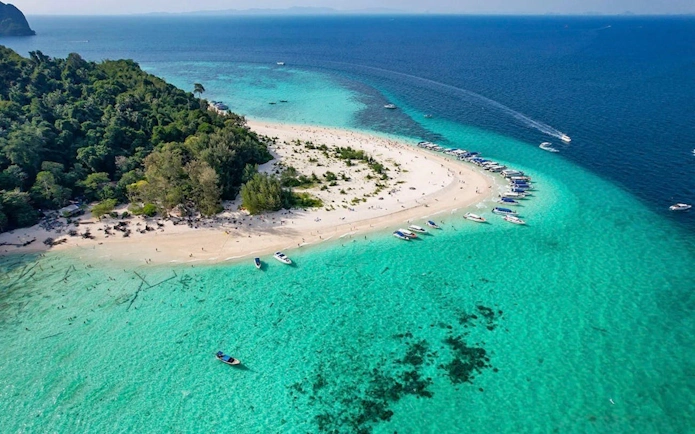 Aerial view of Bamboo Island with speedboats and turquoise waters, part of the Phi Phi tour from Phuket.