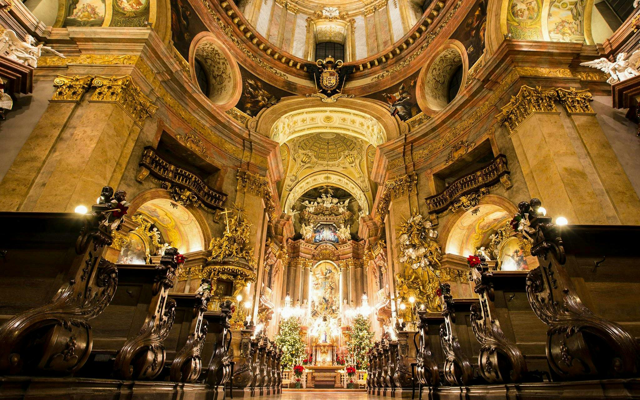 Baroque interior of St. Peter's Church in Vienna with ornate altar and gilded decorations.