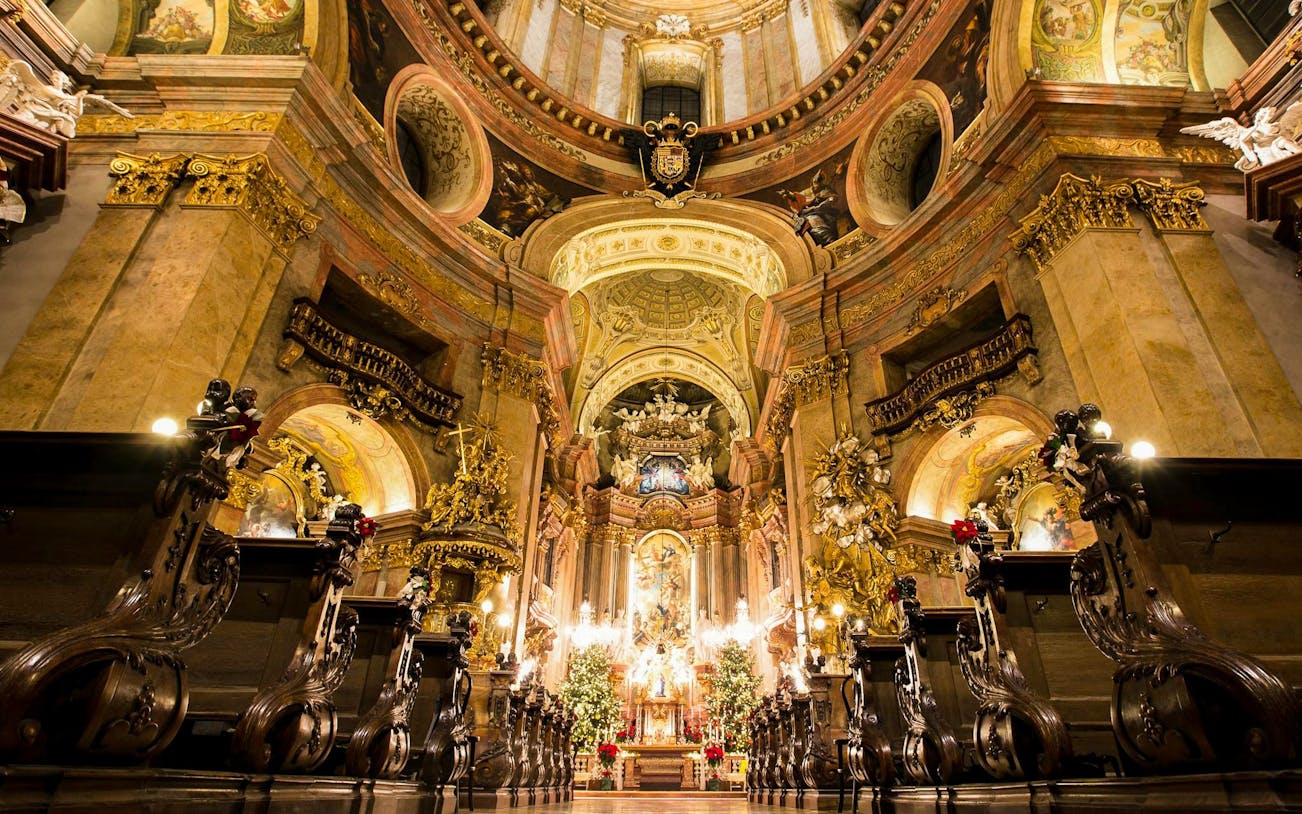 Baroque interior of St. Peter's Church in Vienna with ornate altar and gilded decorations.