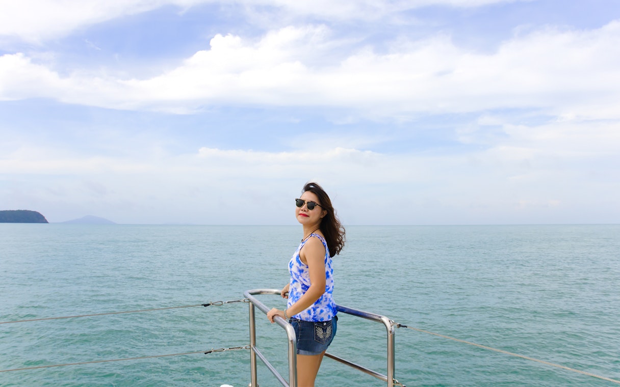 Woman enjoying ocean view on ferry from Singapore to Desaru Coast.