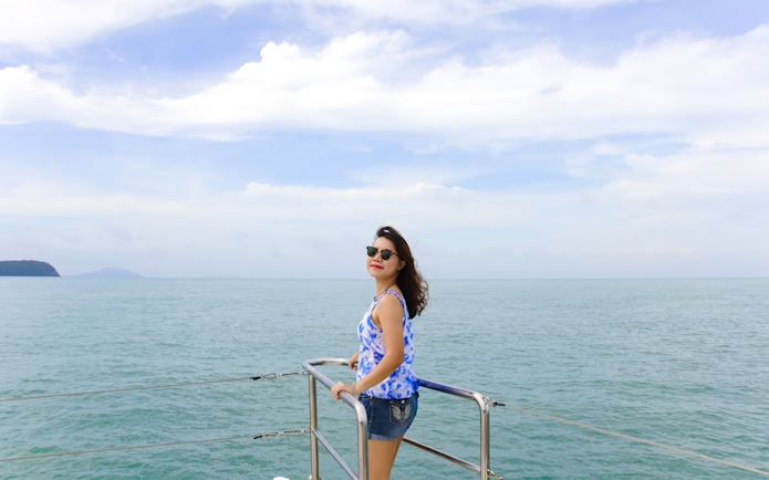 Woman enjoying ocean view on ferry from Singapore to Desaru Coast.