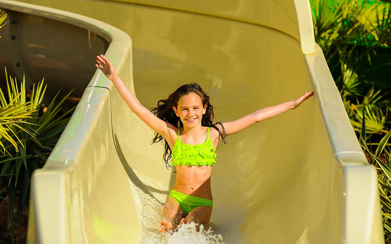 Child enjoying a water slide at Zoomarine Portugal.