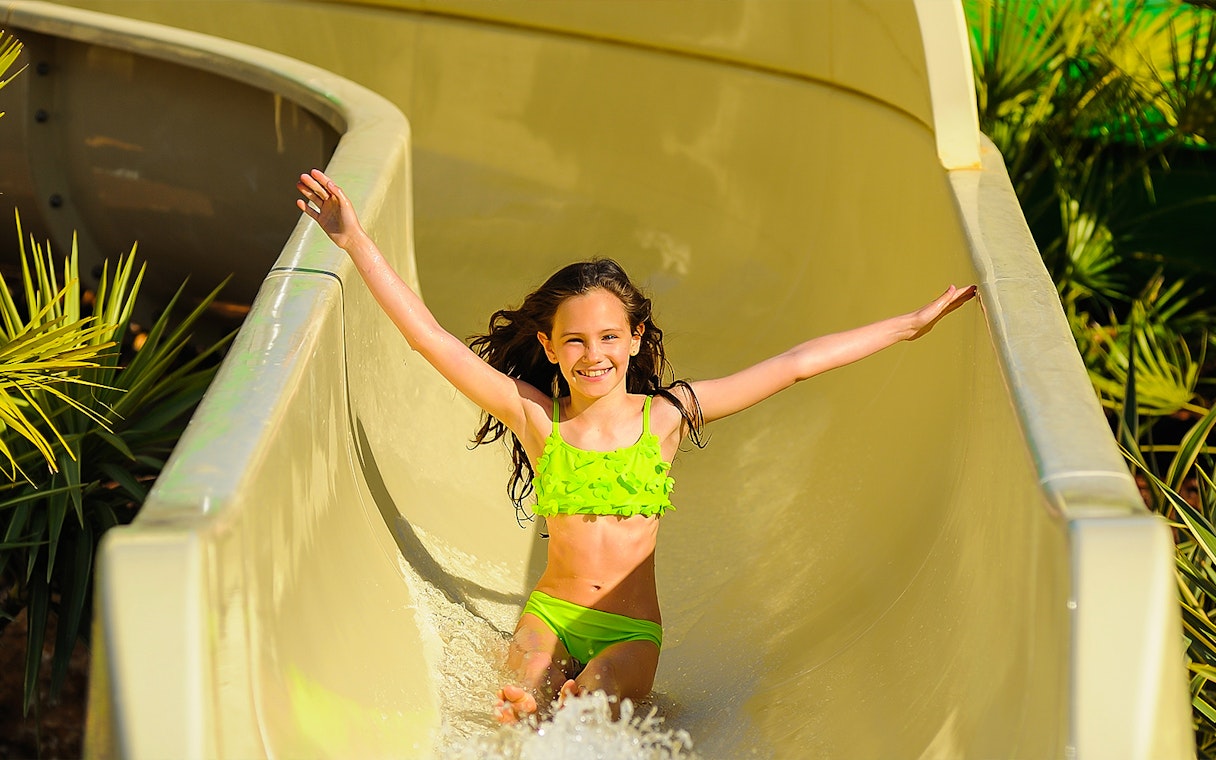 Child enjoying a water slide at Zoomarine Portugal.