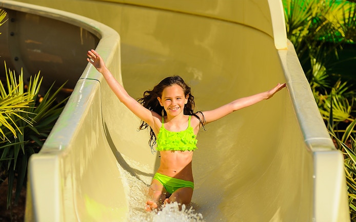 Child enjoying a water slide at Zoomarine Portugal.