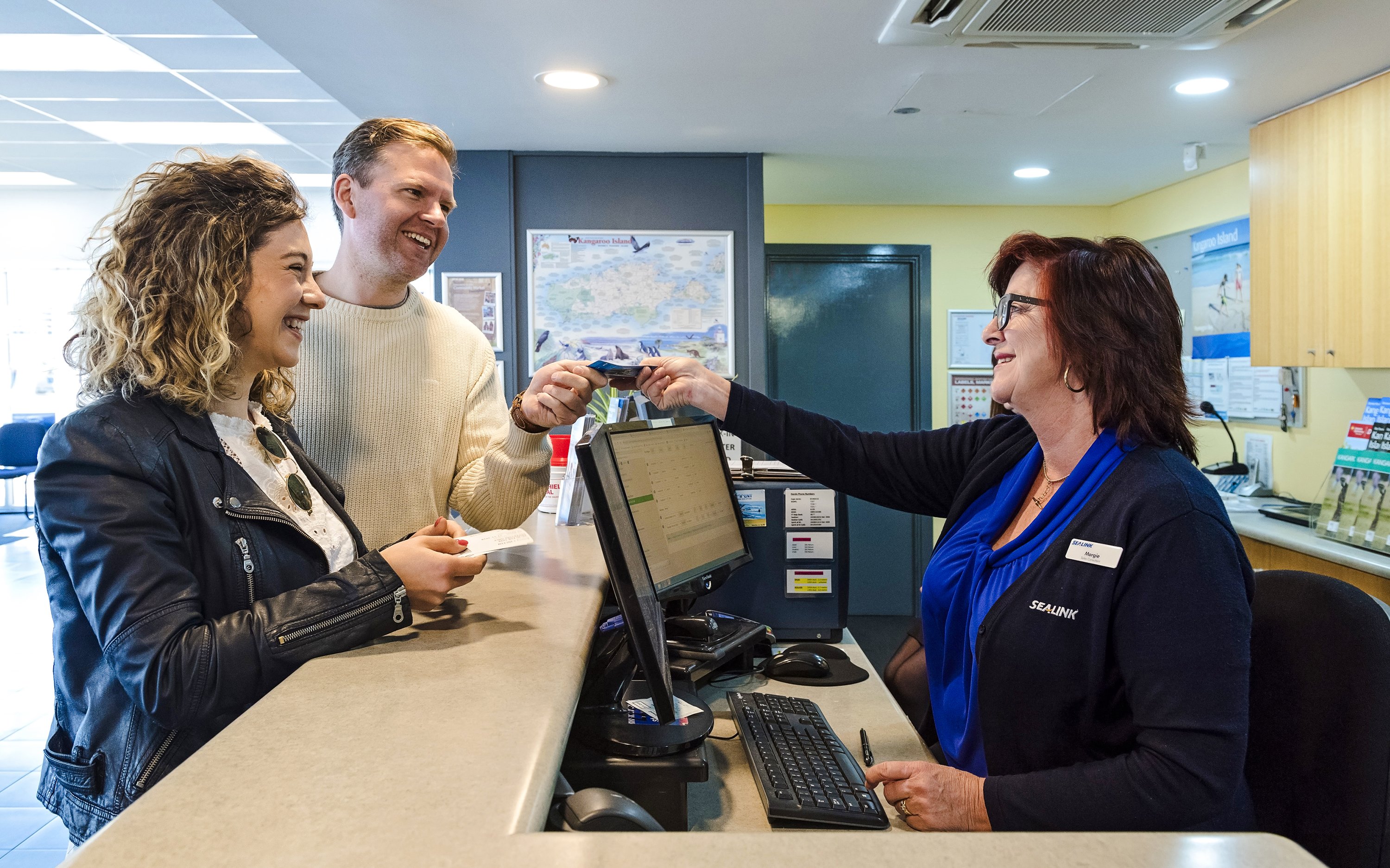 Couple receiving ferry tickets at Kangaroo Island counter.