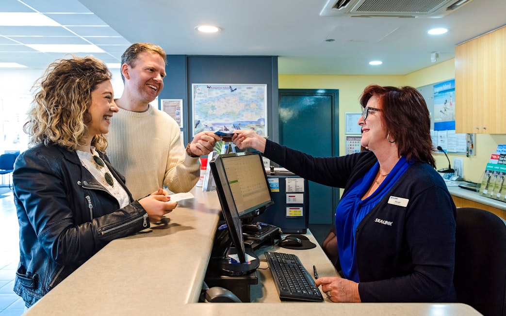 Couple receiving ferry tickets at Kangaroo Island counter.
