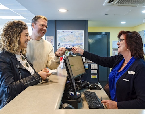 Couple receiving ferry tickets at Kangaroo Island counter.