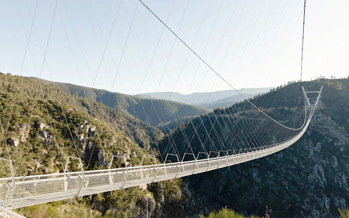 Ponte 516 Arouca suspension bridge spanning a lush valley in Arouca Geopark, Portugal.