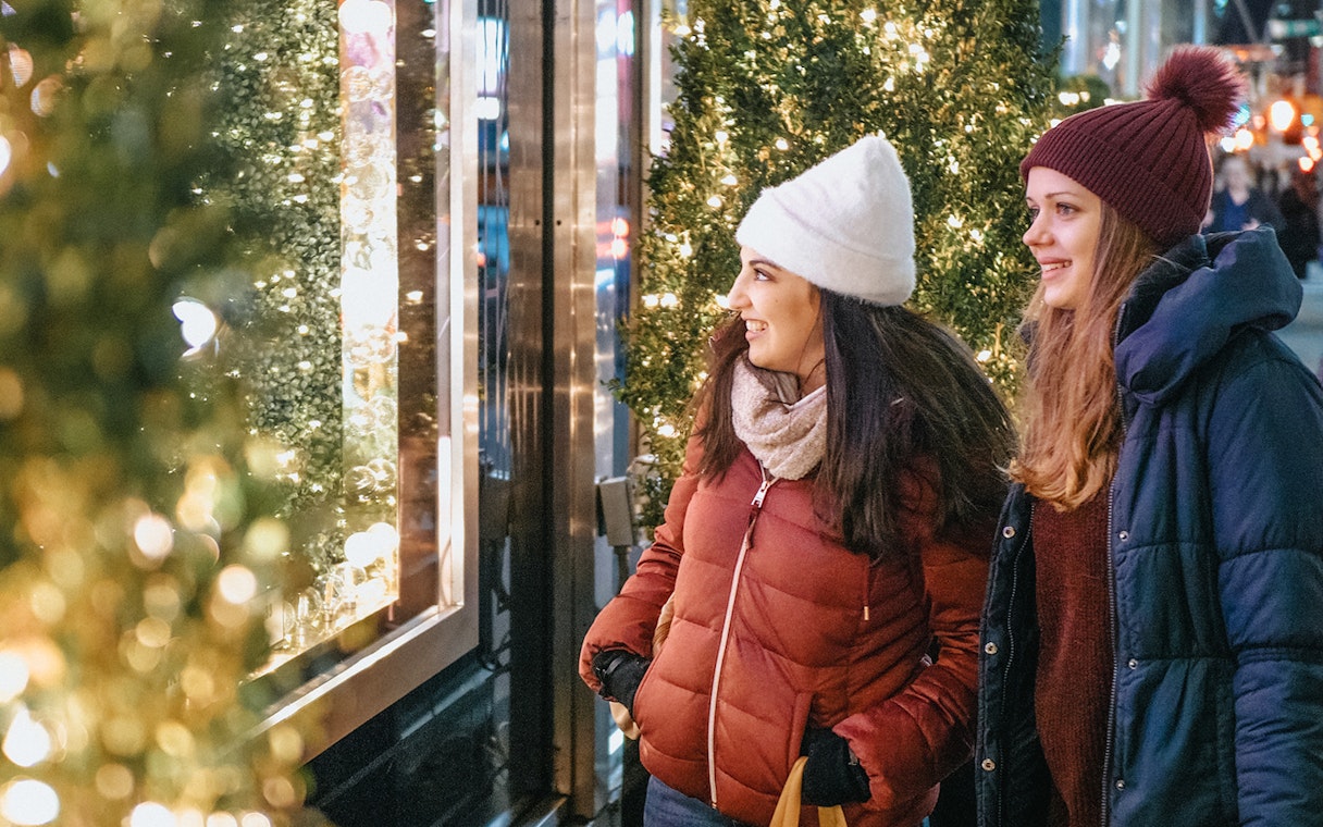 Two people enjoying holiday lights display during a city tour.