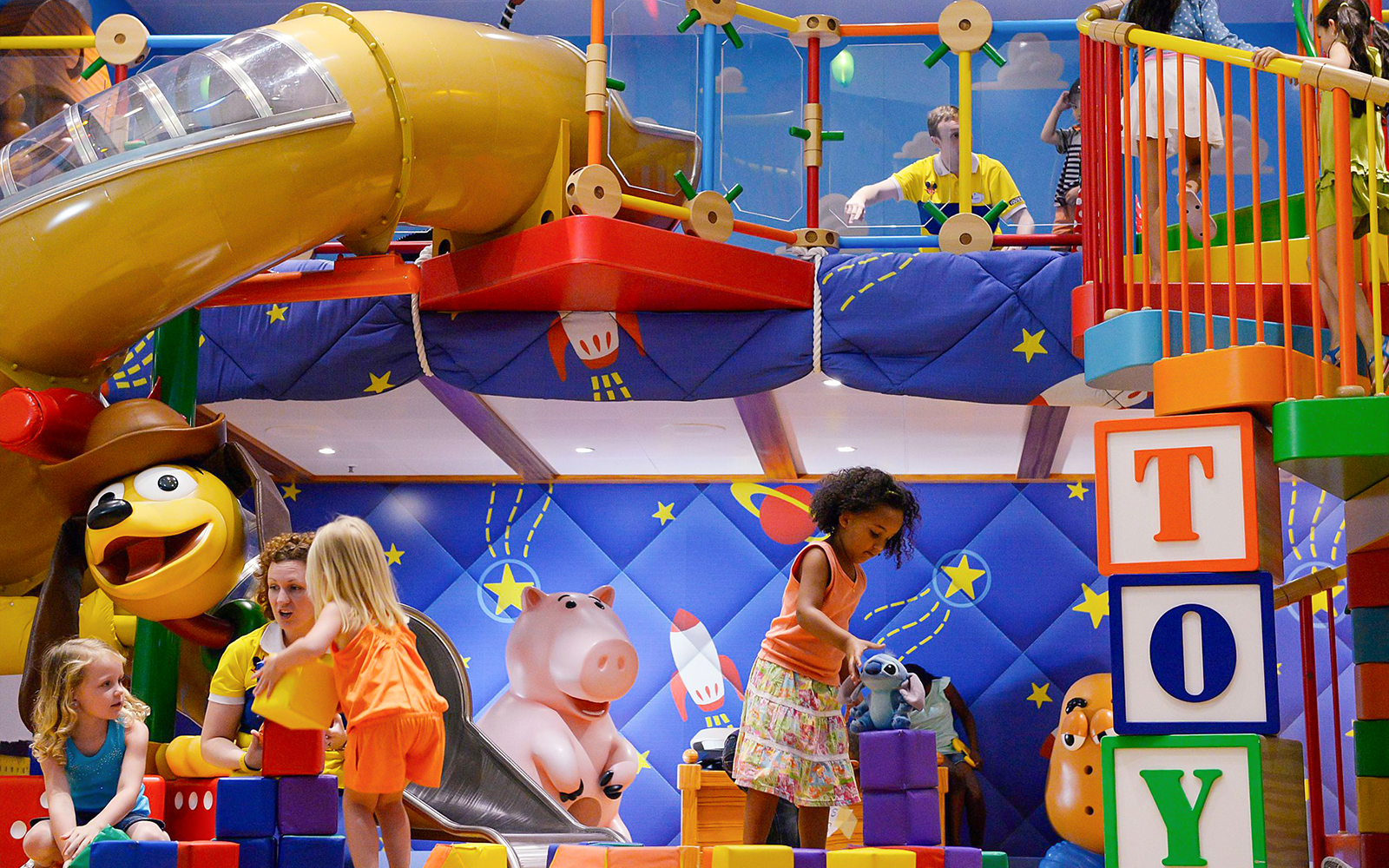 Kids playing in a Disney-themed club with colorful toys and slides on a Disney Adventure Cruise.