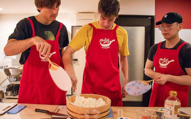 Participants preparing rice in a Tokyo izakaya-style cooking class.