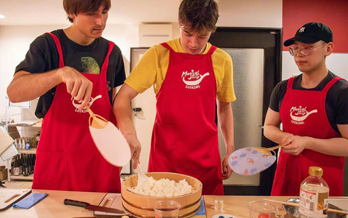 Participants preparing rice in a Tokyo izakaya-style cooking class.