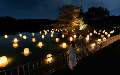 Glowing spheres in a forest setting at teamLab Botanical Garden Osaka art installation.