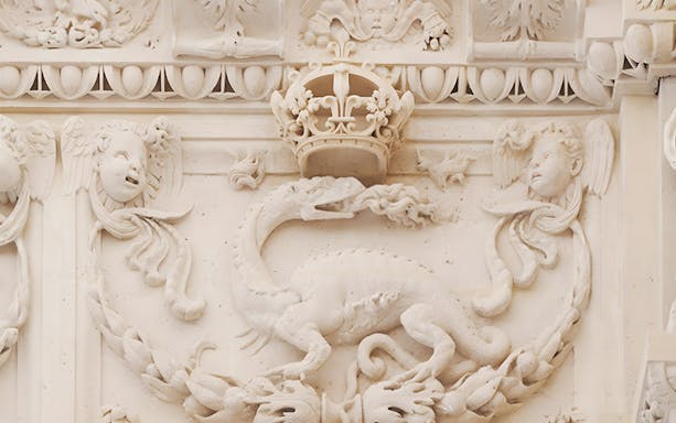 Stone relief of a dragon and crown at Cité internationale de la langue française.
