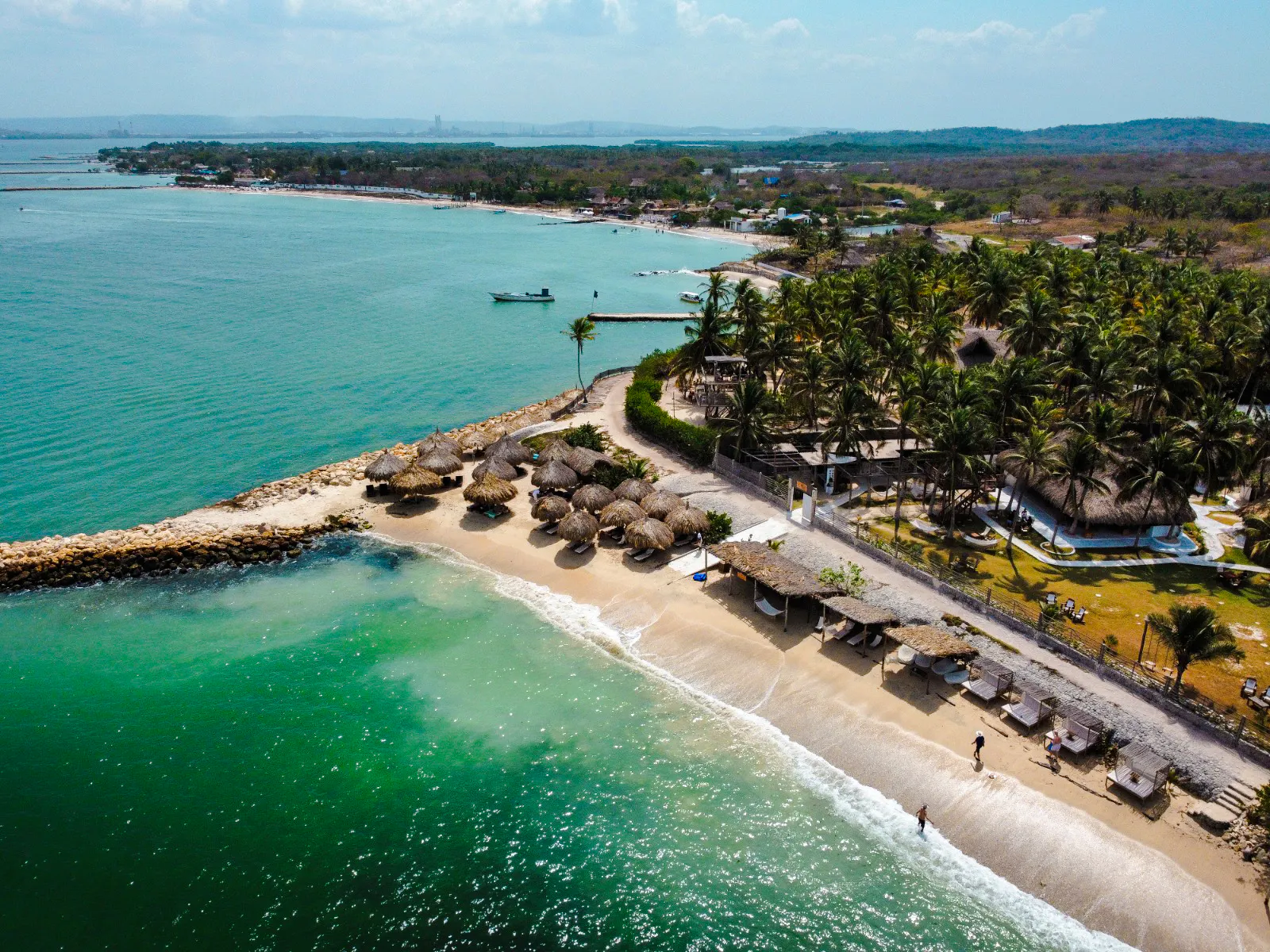 Rosario Islands beach with palm trees and huts, Cartagena day trip experience.