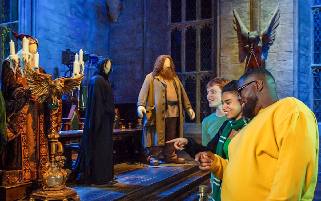 Visitors at Harry Potter Warner Bros. Studio Tour viewing character costumes.