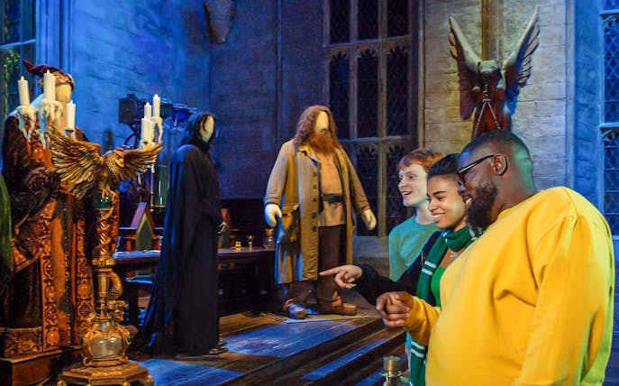 Visitors at Harry Potter Warner Bros. Studio Tour viewing character costumes.