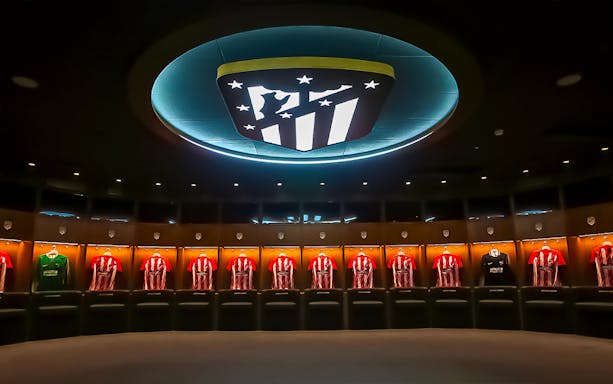 Atletico de Madrid locker room with team jerseys on display.